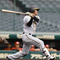 Japanese free agent outfielder Kosuke Fukudome, left, shows his