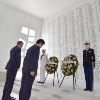 Abe and Obama observe a moment of silence in front of a wall bearing the names of the victims of the Japanese attack on Pearl Harbor, at the USS Arizona Memorial in Oahu, Hawaii, in 2016. Abe was the first sitting Japanese leader to visit the memorial. | KYODO
