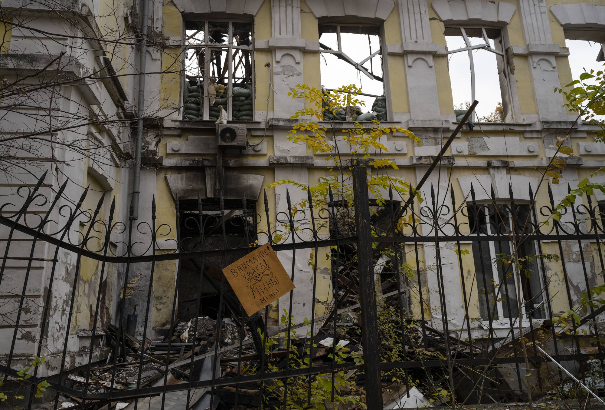 A sign warning of mines hangs in front of the former Russian barracks in the recently liberated city of Kherson, Ukraine. | LYNSEY ADDARIO / THE NEW YORK TIMES