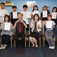 AU students pose with certificates in September after completing the summer intensive English program in Singapore, part of its English Marathon initiatives. | AKITA UNIVERSITY