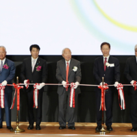 Lower House lawmaker Akira Amari (second from left), Taiwan Semiconductor Manufacturing Co. founder Morris Chang (center) and TSMC Chairman Mark Liu (third from right) pose with other officials at the opening ceremony for its first chip factory in Japan, in the town of Kikuyo, Kumamoto Prefecture, in February. | JIJI