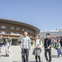 Kyushu U students walk past Shiiki Hall at the university’s Ito Campus.